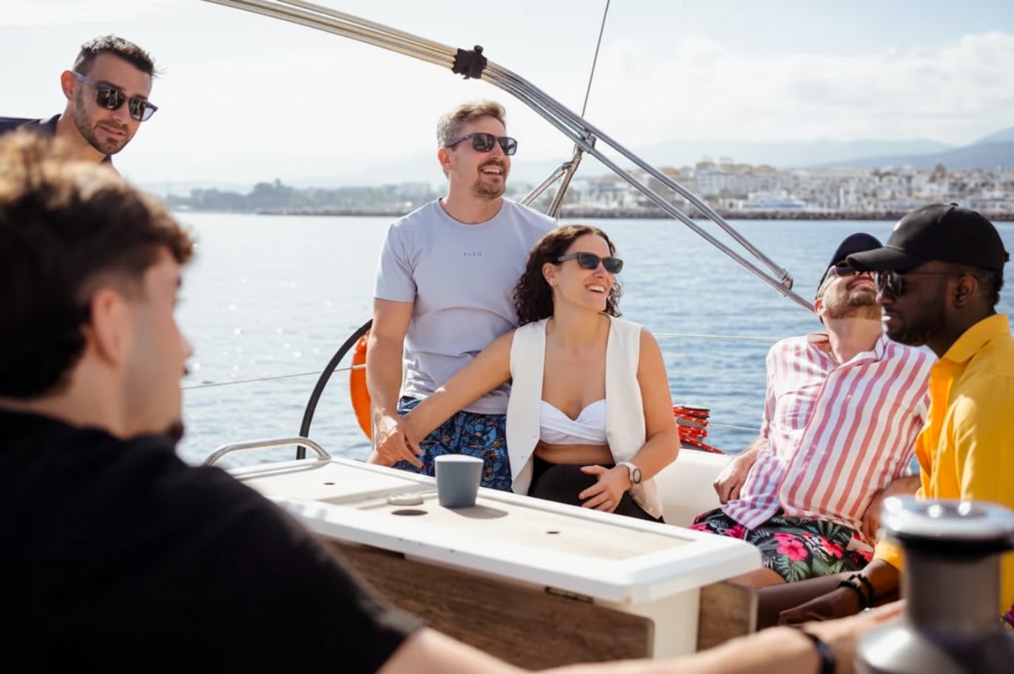Friends relaxing in the cockpit of Váruna, a Dufour 410, on a charter past Puerto Banús, Marbella