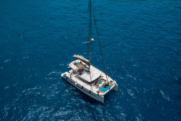 Nereus, a Bali 4.0 catamaran, anchored on turquoise water off Marbella — aerial view