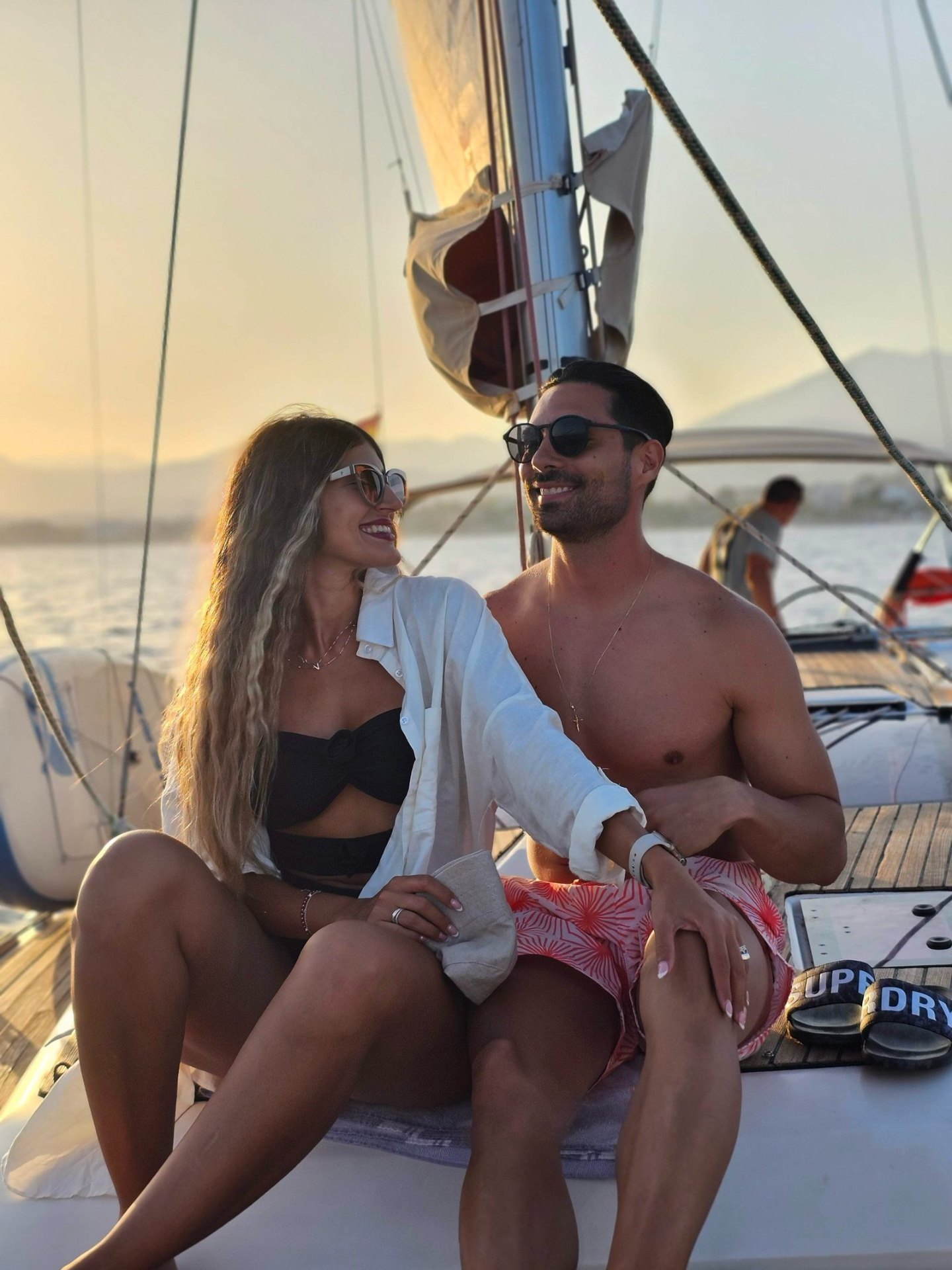 Couple enjoying a sunset sail on deck off Puerto Banús, Marbella
