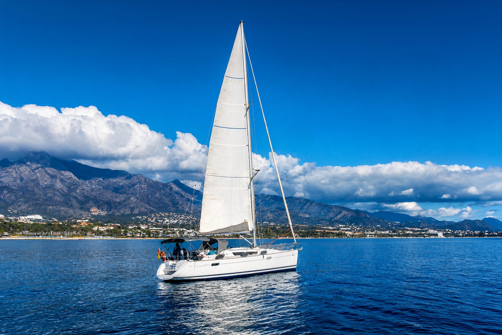 Gran Rick, a Jeanneau Sun Odyssey 39i sailing yacht, under sail off Marbella with La Concha mountain behind