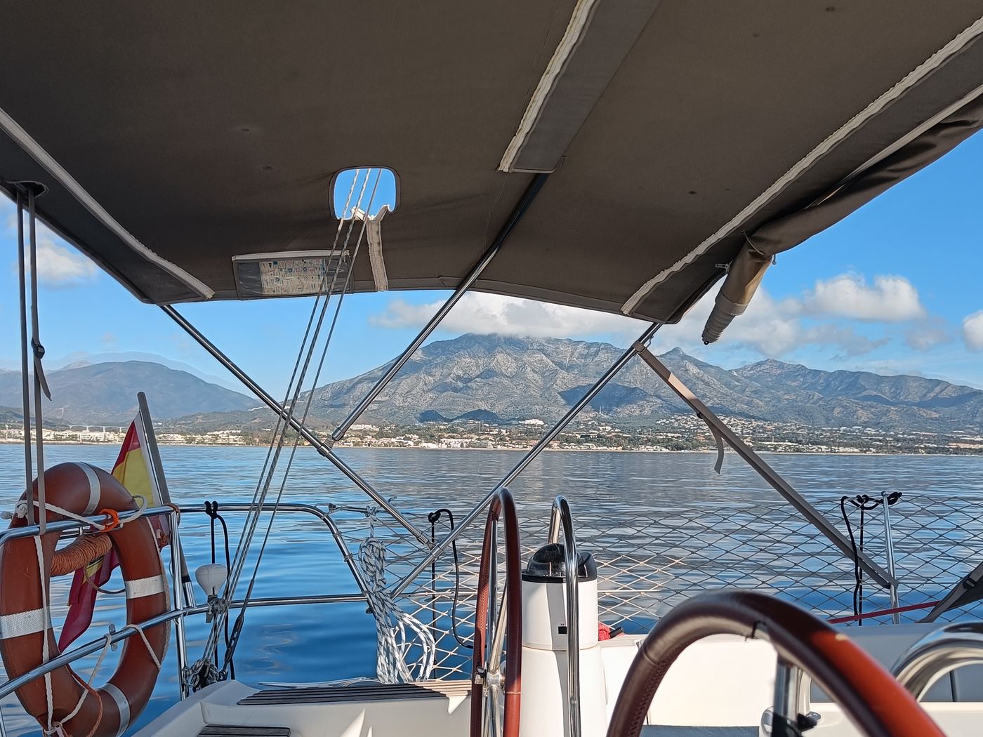 Friends in the cockpit of a Dufour 410 sailing yacht off Puerto Banús, Marbella